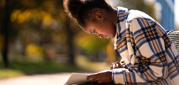 Woman sitting on bench while reading